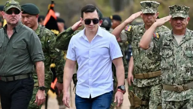 Daniel Noboa caminha entre militares que batem continência.