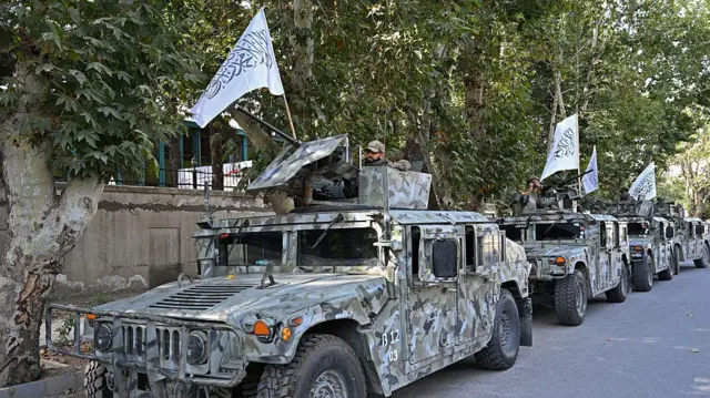 Beyaz Taliban bayrakları taşıyan ABD yapımı humvee jipleri. Jiplerin üzerinde çöl kamuflajı var.
