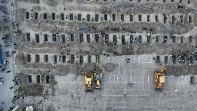 আকাশ থেকে তোলা এই ছবিটি ইরানিয়ান প্রেস সেন্টার গণমাধ্যমকে দিয়েছিল, যেখানে দেখা যাচ্ছে যে একটি স্কুলে হামলায় নিহত শিশুদের কবর খুঁড়ছেন শোকাহত মানুষ