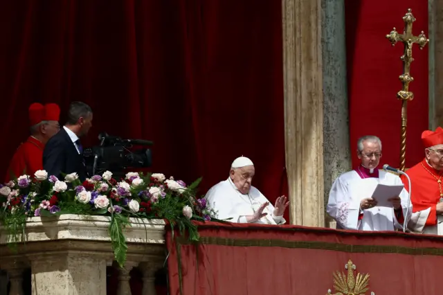 Francisco saluda a los fieles desde el balcón del Vaticano mientras el arzobispo Ravelli lee su mensaje "urbi et orbi".