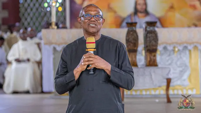 Peter Obi riƙe da abin magana sanye da baƙin tufafi