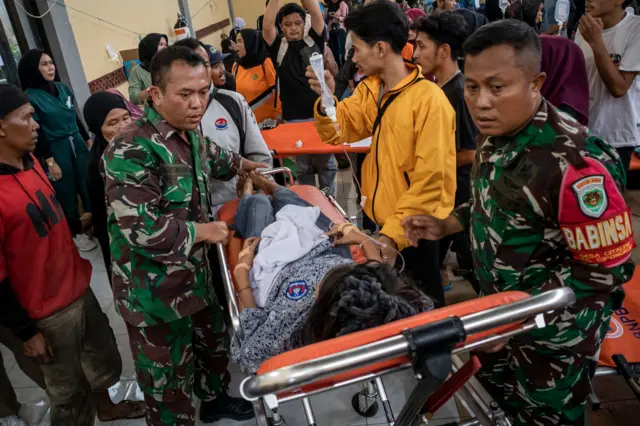 Anggota TNI bersama relawan mengevakuasi korban keracunan di Posko Penanganan di Kantor Kecamatan Cipongkor, Kabupaten Bandung Barat, Jawa Barat, 24 September 2025.