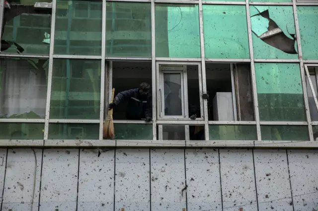 مردی در حال جمعآوری اثار انفجار کابل