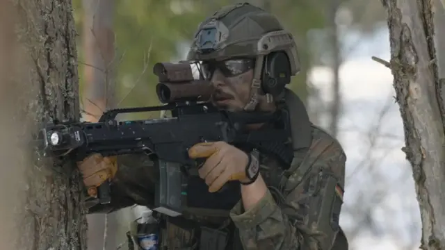 جندي يحمل سلاحاً ويرتدي ملابس مموهة