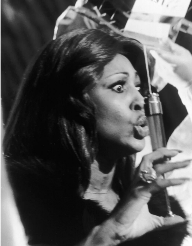 Tina Turner segurando uma seringa com agulha omo a Rainha do Ácidoslot spirit of adventureTommy