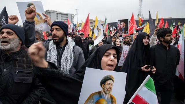 Pro-government people, most of them in black, hold portraits of Iran's new Supreme Leader Ayatollah Mojtaba Khamenei and shout anti-U.S. and anti-Israeli slogans during a rally commemorating International Quds Day, also known as Jerusalem Day, in Tehran, Iran, on March 13, 2026 