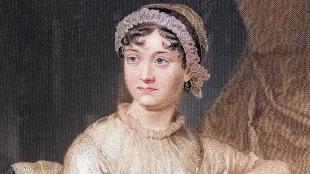 A portrait of Jane Austen from the 1800s. She has curly brown hair in a hat with pink frill detail around the crown of her head. She is wearing a beige blouse type top with ruffles on the neckline and sleeves
