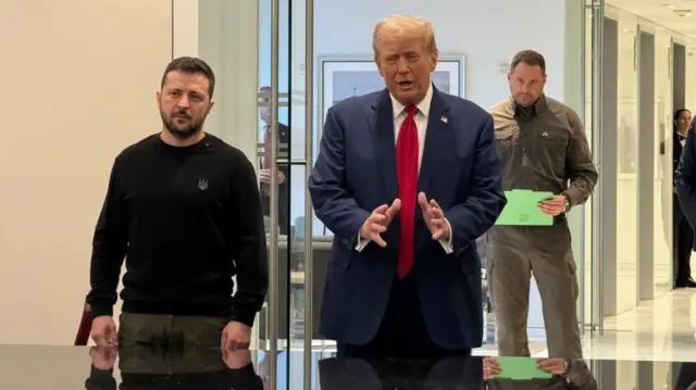 Trump, vestindo terno e gravata vermelha, gesticula com as mãos enquanto fala, ao lado do presidente ucraniano Volodymyr Zelensky, que veste calças cáqui e um moletom preto, em uma sala de reuniões em Nova York em setembro de 2024