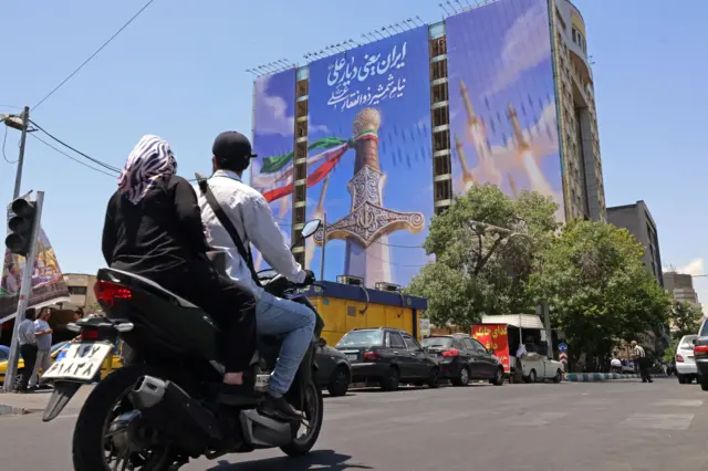 لافتة في ساحة ونك بطهران تجمع بين رمزية دينية وصواريخ إيرانية، في وقت قالت وزارة الخارجية الإيرانية إن الضربات الأمريكية الأخيرة أضرت بالجهود الدبلوماسية الرامية إلى إنهاء الحرب.