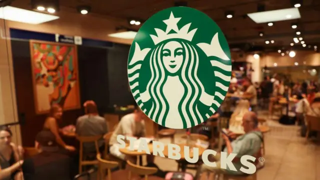 Uma loja da Starbucks ao fundo com o logotipo da empresasoccer bet proprimeiro plano