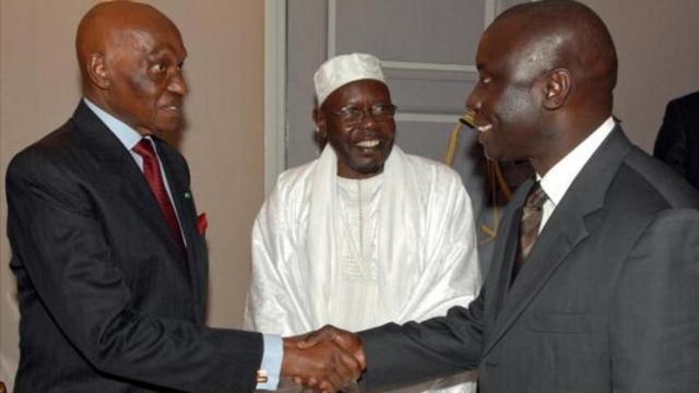 Poignée de main entre Abdoulaye Wade (à gauche) et Idrissa Seck en février 2007 au palais présidentiel, en présence de Serigne Abdou Aziz Sy, porte-parole du khalife général des tidjanes, après une violente rupture entre le lieutenant et son mentor.