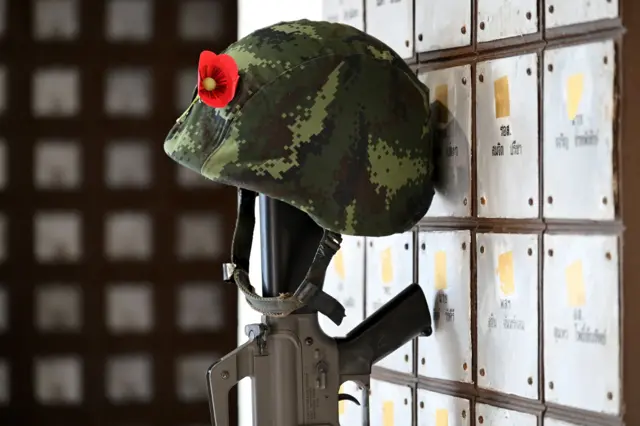 ကျဆုံးစစ်သည် အောက်မေ့ဖွယ်နံရံ ကမ္ဗည်းပြားမှာ ရိုင်ဖယ်သေနတ်တစ်လက်အပေါ် ထောင်ထားတဲ့ စစ်သား ပြောက်ကျား ဦးထုပ်တစ်လုံးနဲ့ ပေါ်ပီပန်းအနီပွင့်တစ်ပွင့်ကို မြင်ရတာဖြစ်ပါတယ် 