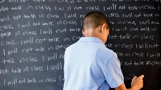 வகுப்பின் கரும்பலகையில் எழுதும் மாணவர் 