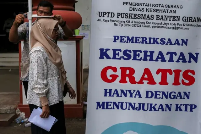 Petugas kesehatan mengukur tinggi badan warga saat cek kesehatan gratis di Kota Serang, Banten, Kamis (15/05).