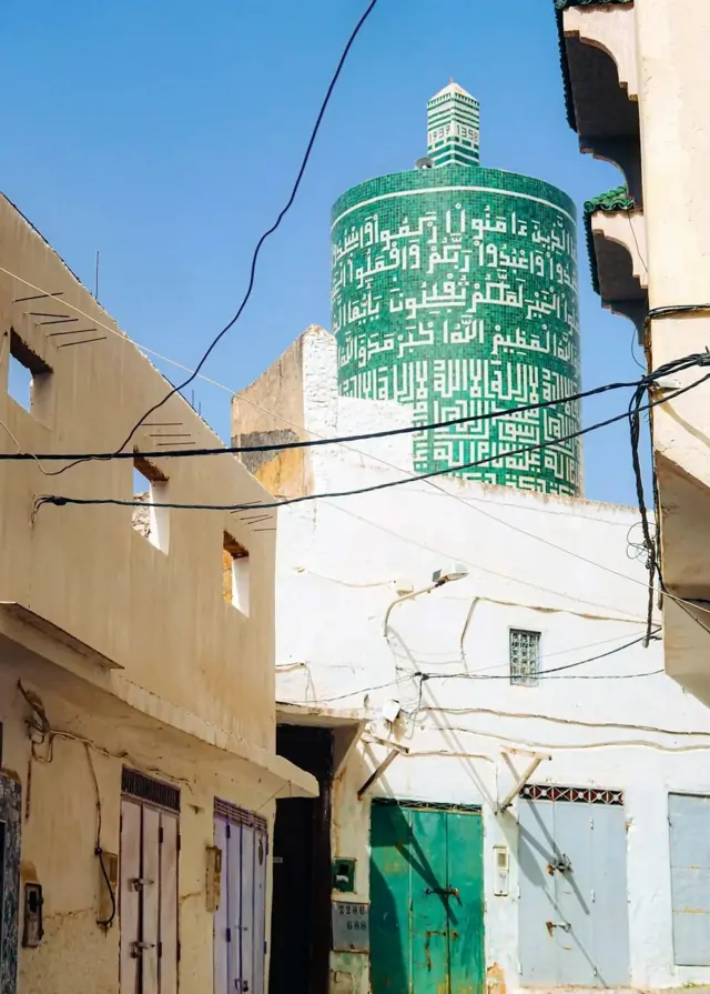 مینار پر خط کوفی میں قرآن مجید کی آیتیں لکھی ہیں