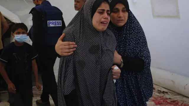 Women cry at the funeral for Wael Al-Dahdouh's family members