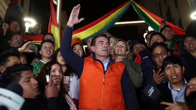 Rodrigo Paz con un chaleco rojo y rodeado de partidarios