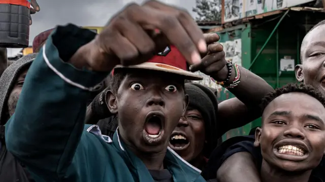 Waandamanaji wakiimba kauli mbiu wakati wa maandamano ya kuunga mkono demokrasia tarehe 7 Julai 2025 jijini Nairobi, Kenya. Waandamanaji walijibu wito wa mashirika ya kiraia na makundi mengine kujitokeza mitaani. Kijana akiwa mdomo wazi akiimba huku akiwa amezungukwa na vijana wengine pia wakiimba.