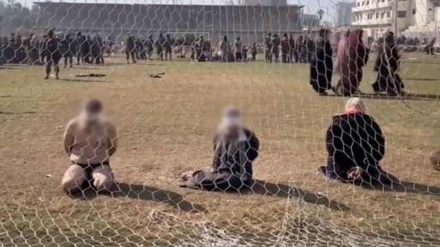 چند مرد و زن با چشمان بسته پشت دروازه فوتبال استادیومی در غزه زانو زده‌اند