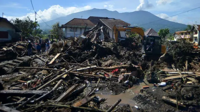 Operator mengoperasikan alat berat saat pencarian korban banjir bandang di Jorong Galuang, Nagari Sungai Pua, Agam, Sumatera Barat, Senin (13/5/2024).