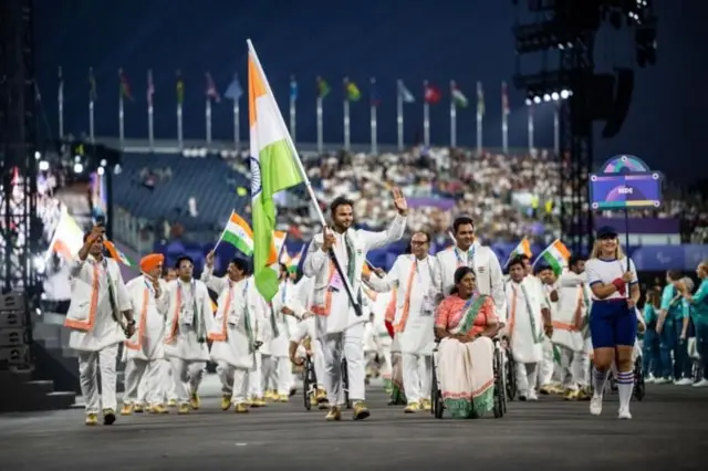 પેરિસ પૅરાલિમ્પિકમાં ધ્વજવાહક તરીકે આગળની તરફ સુમિત અંતિલ, ભાગ્યશ્રી જાધવ અને ટીમ ઇન્ડિયા