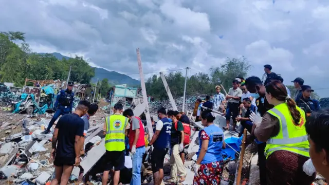 အပျက်အစီးပုံကြားထဲ ပိတ်မိနေတဲ့အလောင်းတချို့ကို ဆွဲထုတ်နေတဲ့မြင်ကွင်း