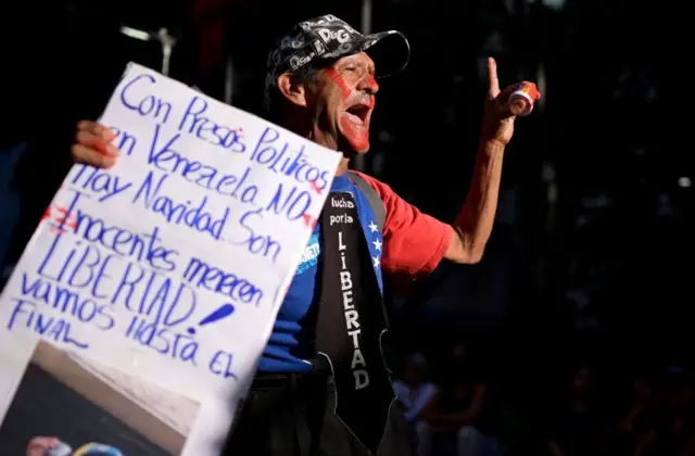 Un hombre con un cartel en Caracas