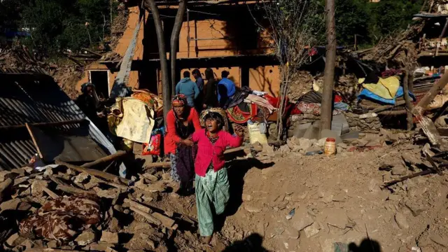 भत्किएको घर अगाडी रुदैँ एक भूकम्प पीडित महिला 