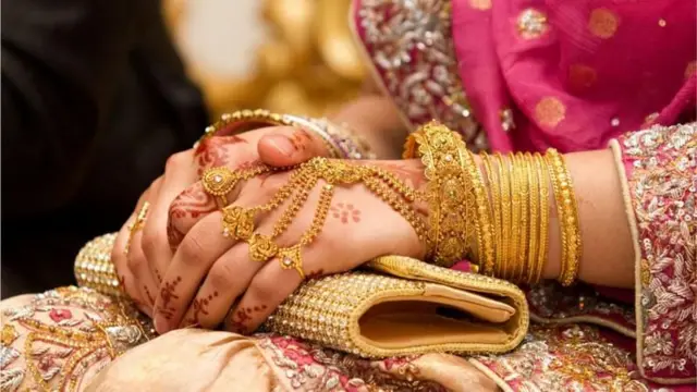 সোনার গয়না পরা এক নারীর হাত
