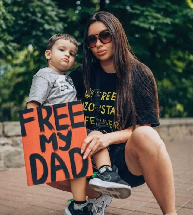 Мама з хлопчиком і написом "Free my dad"