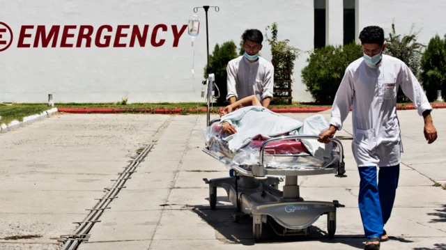 انتقال یکی از مجروحان توسط کارمندان شفاخانه ایمرجنسی