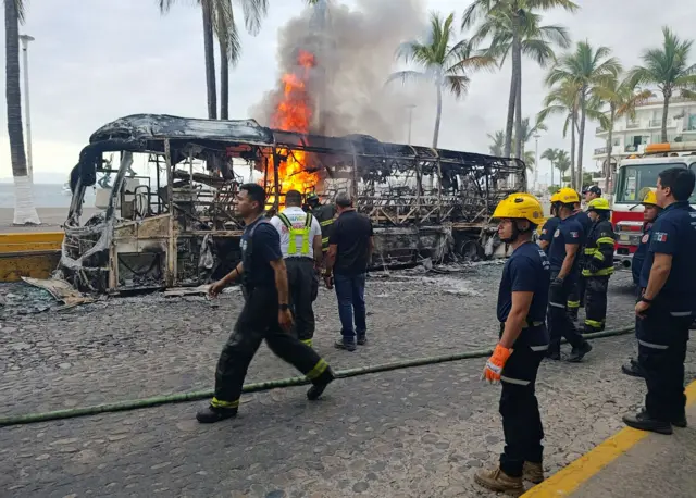Firefighters work to off fire wey dey burn one bus for Puerto Vallarta, Mexico.