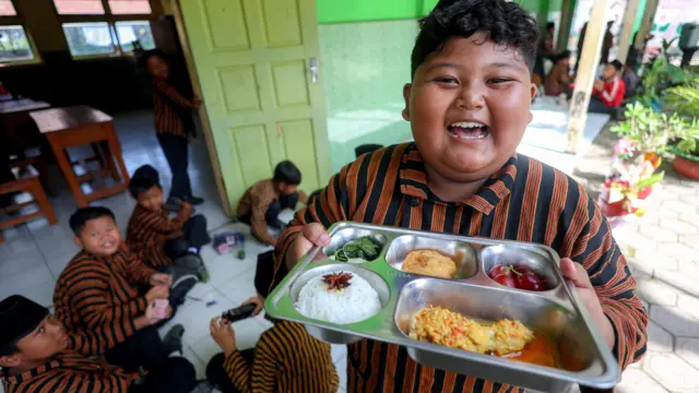 Siswa menunjukan paket makanan menu kuliner nusantara untuk program Makan Bergizi Gratis (MBG) di SD Negeri Tanjunganom 3, Nganjuk, Jawa Timur, Kamis (8/1/2026).