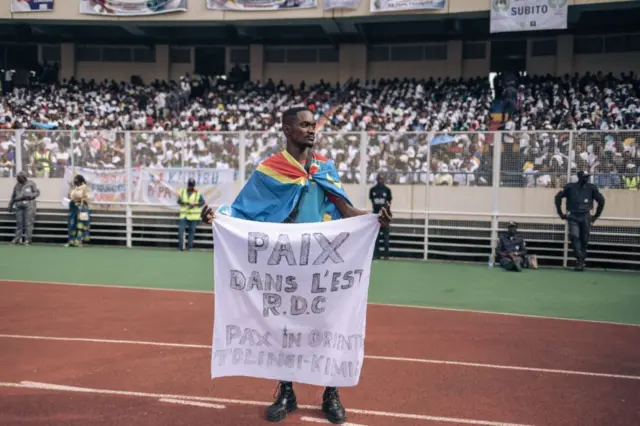 Un jeune homme avec une banderole.