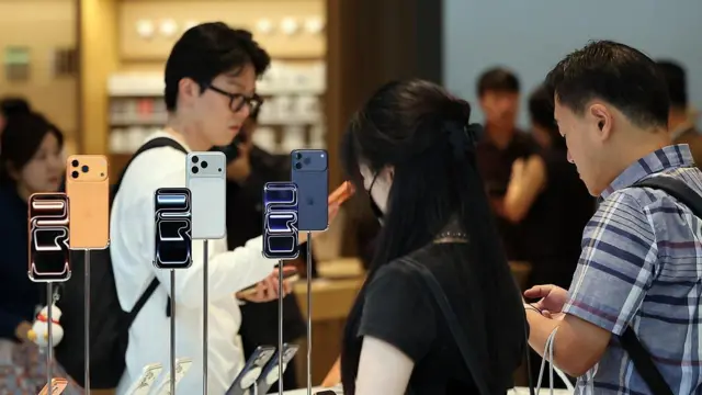 人们在苹果专卖店内查看 iPhone。