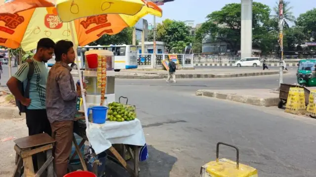 রাস্তায় লেবুর শরবত বিক্রি করছেন একজন।