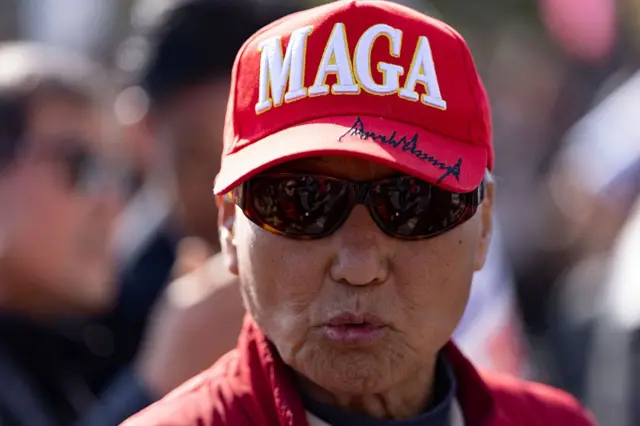 MAGA စာတန်း ပါ ဦးထုပ် နဲ့ အတူ တွေ့ရတဲ့ အမေရိကန် နိုင်ငံသားတစ်ဦး