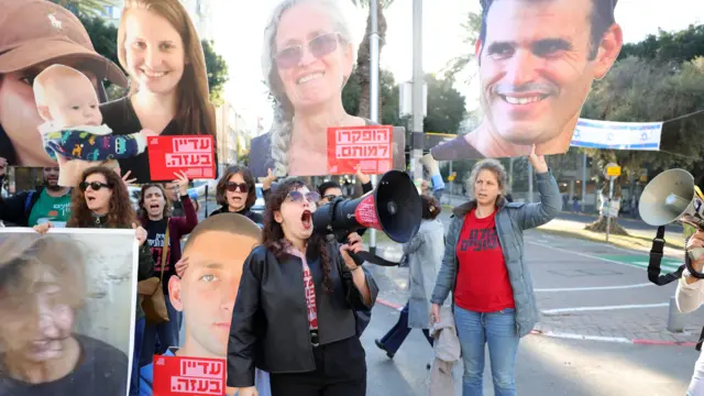 Families of hostages held by Hamas in Gaza and their supporters carry pictures of hostages outside the Likud Party headquarters on 8 January 2025, during a protest calling for a ceasefire and hostage releases
