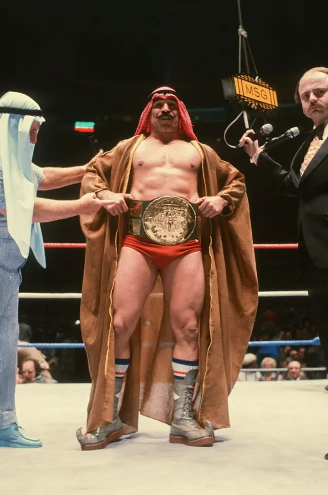 El Jeque de Hierro posa con el título mundial de lucha libre.