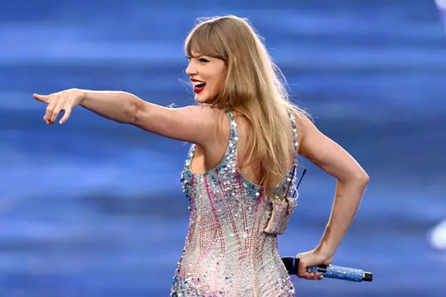 Taylor Swift sorrindo e apontando para o públicovulcan slotshow