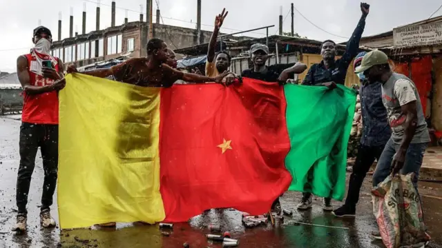 Some young men hold Cameroon flag