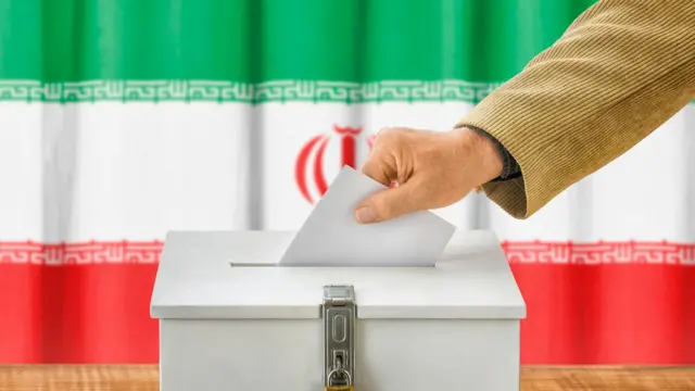 تصویر فردی در حال رای دادن در حالی که پرچم جمهوری اسلامی در پس زمینه دیده می‌شود