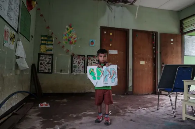 Seorang siswa TK dengan kertas gambarnya di dalam sekolahnya yang rusak akibat gempa bumi tahun lalu di Tanjung, Lombok, Nusa Tenggara Barat pada 22 Januari 2019.