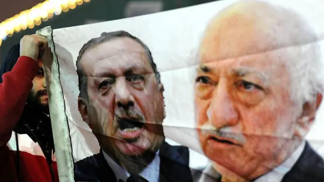 يرفع متظاهر تركي (يسار) لافتة تحمل صور رجب طيب أردوغان (وسط) وفتح الله غولن (يمين) خلال مظاهرة احتجاجاً على الحكومة في 30 ديسمبر/كانون الأول 2013 في مدينة إسطنبول.
