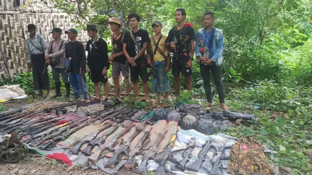 လက်ပံတန်းမြို့နယ်ထဲမှာ သြဂုတ် ၂၄ ရက် တိုက်ပွဲအတွင်း ပြည်သူ့ကာကွယ်ရေးတပ်ဖွဲ့(ပကဖ) ဘက်က စစ်ကောင်စီတပ်ဖွဲ့ဝင်တွေဆီကနေ သိမ်းဆည်းရရှိတဲ့ လက်နက်တွေ လို့ ဆိုပြီး အမျိုးသားညီညွတ်ရေးအစိုးရ(NUG) ကာကွယ်ရေးဝန်ကြီးဌာနက သတင်းထုတ်ပြန်ပါတယ်။ မြေပြင်က ပိုက်လုံးအိပ်ယာအခင်းတွေပေါ် ဖြန့်ထားတဲ့ စစ်ကောင်စီတပ်ဖွဲ့ဝင်တွေရဲ့ သေနတ်တွေ ကျည်ဆန်တွေ ကျည်ကာ ဦးထုပ်တွေကို ဖြန့်ခင်း ထားပါတယ်။ အဲဒီနောက်မှာတော့ ပကဖ အဖွဲ့ဝင်တွေက ၉ ဦးက တန်းစီ မတ်တပ်ရပ်ပြီး ဓာတ်ပုံ အရိုက်ခံနေတာတွေ့ရပါတယ်။ 