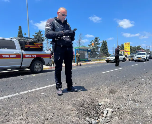 Israeli police inspect the site where the shell fell