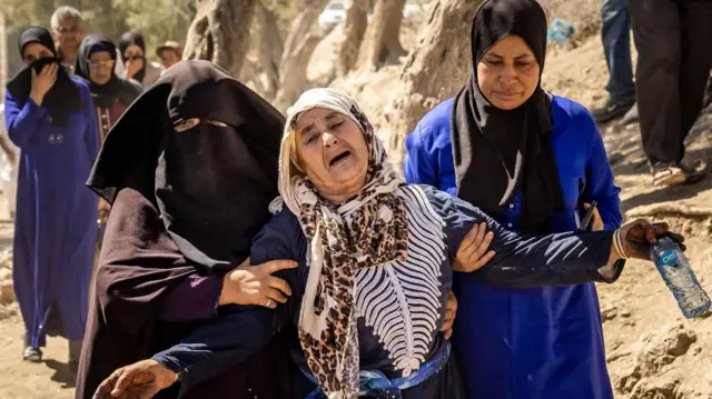 زنی پس از جان باختن بستگانش در زمین‌لرزه مراکش در سال ۲۰۲۳، از سوی اطرافیان دلداری داده می‌شود