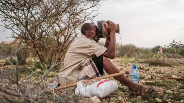 Ali Abdi Elmi drinks from a cup filled with camel milk, in the outskirts of the city of Hargeisa, Somaliland