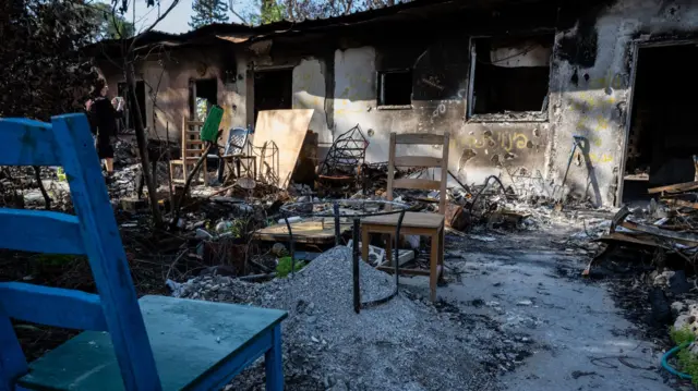 Chairs sit beside piles of burned debris sifted to find human remains, as Israeli residents of the Nir Oz kibbutz grapple with being overrun by Palestinian Hamas militants from the nearby Gaza Strip on 6 December 2023