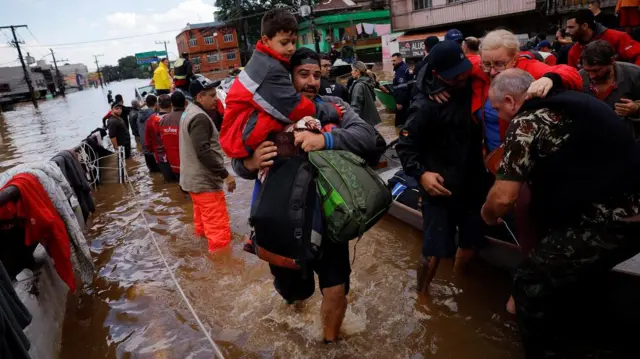 Pessoas sendo resgatadasbet88barco durante tragédia no Sul